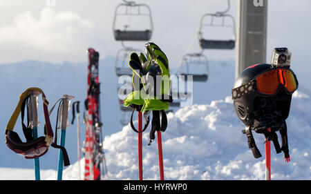 Schützende Sportgeräte auf Skistöcke im Skigebiet am sonnigen Abend Stockfoto