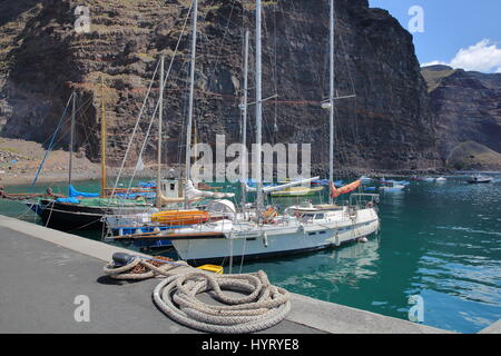 VALLE GRAN REY, LA GOMERA, Spanien - 19. März 2017: Das Dorf von Vueltas mit Segelbooten und Klippen im Hintergrund Stockfoto