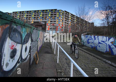 Mann, Radfahren durch Park Hill Wohnsiedlung, ein Brutalist Wahrzeichen der Stadt Sheffield Skyline und das größte denkmalgeschützte Bauwerk in Europa Stockfoto