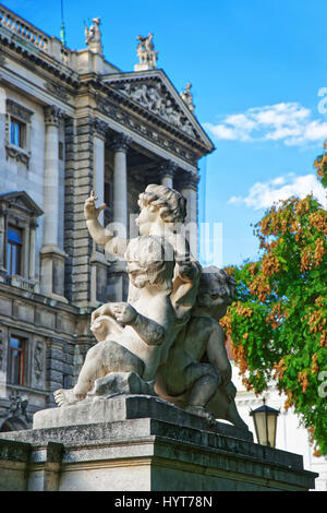 Statue von Putten Engel im Burggarten, Wien in Österreich. Neue Burg der Hofburg im Hintergrund Stockfoto