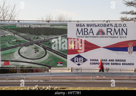 Belgrad, Serbien - 25. Dezember 2014: Frau vorbei an einer Plakatwand Förderung der chinesischen Investitionen in Serbien in der Nähe der neu eröffneten Pupin Brücke über die Stockfoto