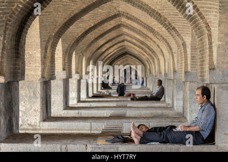 ISFAHAN, IRAN - 20. AUGUST 2016: iranische Volk unter den Bögen der Khaju Brücke ruht, in Isfahan, in den wärmsten Stunden des Sommers Bild eines Ir Stockfoto