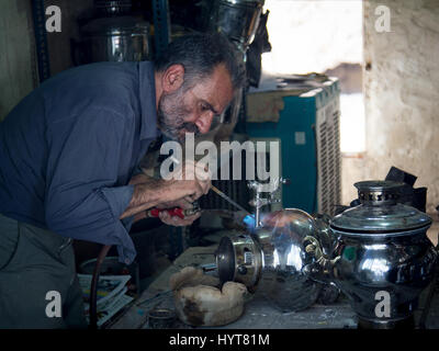 KASHAN, IRAN - 13. August 2016: Crafstman Reparatur ein Samowar in Kashan Basar, Iran Samoware (manchmal auch buchstabiert Samavar oder Samaavar) sind gebrauchte t Stockfoto