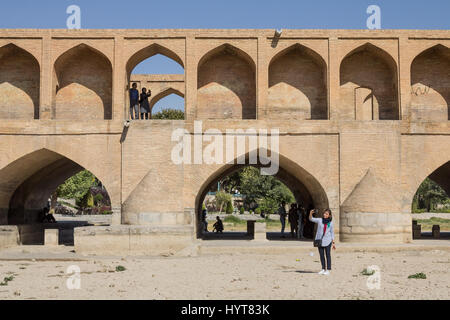 ISFAHAN, IRAN - 20. August 2016: Menschen, die die Selfies, auf und neben Si o Seh Pol Brücke im Iran iranische Mädchen Kopf mit einem Schal, wobei eine Sel bedeckt Stockfoto