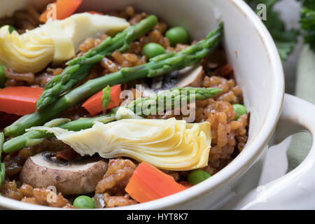 Gesunde Schale mit veganen Paella mit Spargel, Champignons und Artischockenherzen. Stockfoto