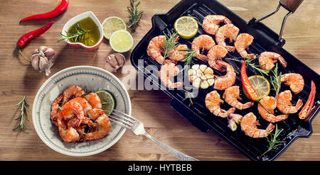 Garnelen gebraten mit Zitrone, Rosmarin und Knoblauch auf Grillpfanne. Ansicht von oben Stockfoto