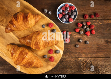 Knusprige französische Croissants mit frischen Himbeeren und Heidelbeeren Stockfoto