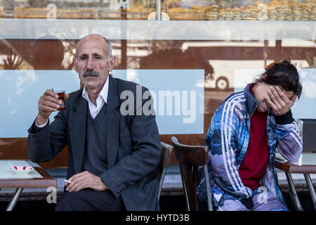 ISTANBUL, Türkei - 28. Dezember 2015: Greis Teetrinken auf der Terrasse eines Cafés auf der asiatischen Seite der Stadt Bild ein gealterter Mann, Blick auf die Stockfoto