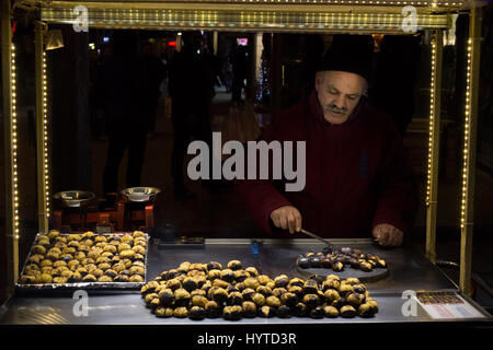 ISTANBUL, Türkei - 28. Dezember 2015: Bild von einem alten Kastanie Verkäufer an einem kalten Winterabend auf der Istiklal Straße Stockfoto