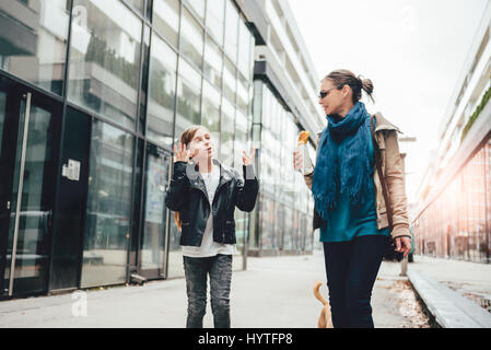 Mutter und Tochter hinunter die Straßen der Stadt und Essen sandwich Stockfoto