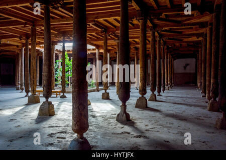 Sonne Strahlen durch viele geschnitzten Holzsäulen in der alten Madrassa in Chiwa, Usbekistan Stockfoto