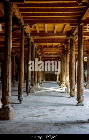 Sonne Strahlen durch viele geschnitzten Holzsäulen in der alten Madrassa in Chiwa, Usbekistan Stockfoto