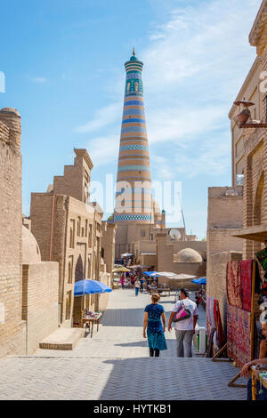 CHIWA, Usbekistan - SEPTEMBER 7: Passanten in Khiva Altstadt und Minarett hinter der engen Gassen. September 2016 Stockfoto