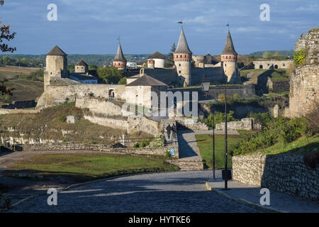 Blick auf den meisten Zamkowy und Burg von Kamenez-Podolsk in der Westukraine, aufgenommen an einem sonnigen Herbsttag. Die gepflasterte Straße führt das Auge über die Stockfoto