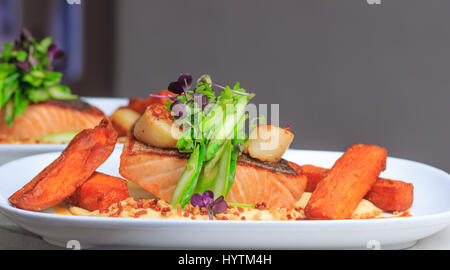 Gegrillte knusprige Haut Lachsfilet mit Jakobsmuscheln servierfertig in einem Restaurant, Gasto Pub, Australien Stockfoto