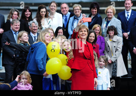 SNP Führer und schottischen ersten Minister Nicola Sturgeon nimmt ein Selbstporträt mit einer Gruppe von Kindern, nachdem er eine Rede in South Queensferry, mit einigen der neu gewählte SNP MPs im Hintergrund Stockfoto