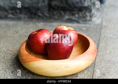 Rote Äpfel auf Holzplatte Stockfoto