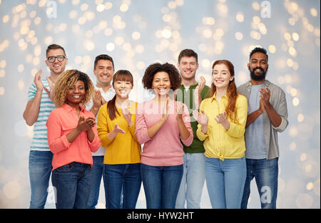 internationale Gruppe von fröhlichen Menschen applaudieren Stockfoto