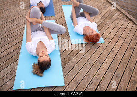 Gruppe von Menschen, die Yoga-Übungen im freien Stockfoto