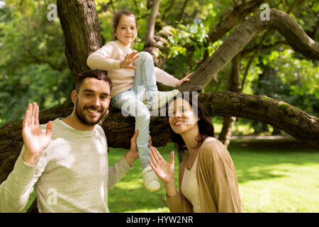 Happy Family im Sommerpark winken Hände Stockfoto