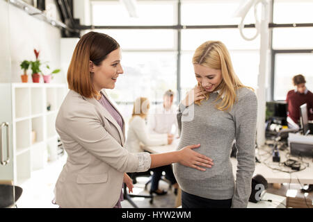 glücklich Kollege mit schwangeren Frau im Büro Stockfoto