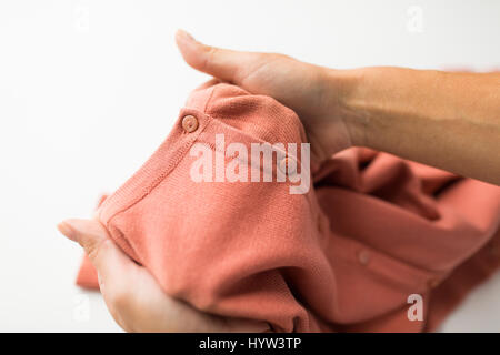 Nahaufnahme von Händen mit Kleidungsstück oder Strickjacke Stockfoto