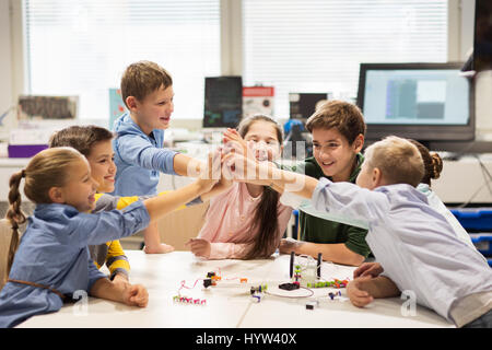 glückliche Kinder machen hohe fünf in der Robotik-Schule Stockfoto