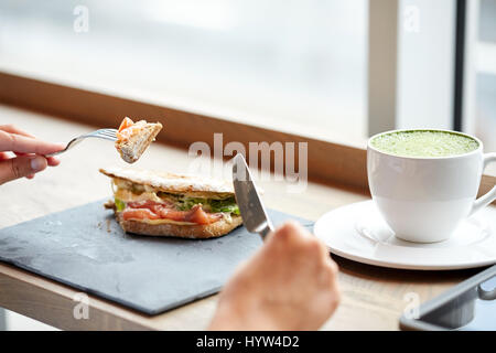 Frau essen Lachs Panini Sandwich Restaurant Stockfoto