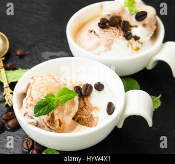 Kaffee und Vanille-Eis-Kugeln in Schalen mit Minze Stockfoto
