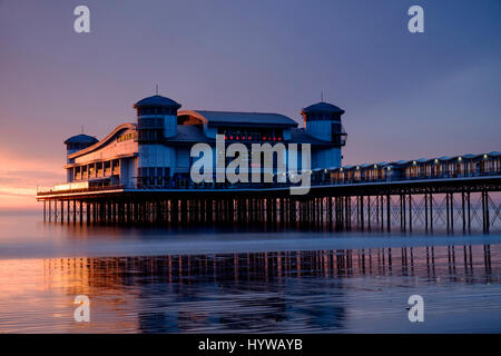 Grand Pier in Weston-Super-Mare spiegelt sich im nassen Sand und Meer bei Sonnenuntergang Stockfoto