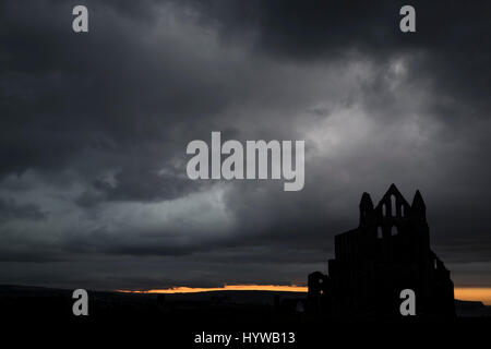 Whitby Abbey Silhouette unter sehr dunkel grau und stürmischen Wolken Stockfoto