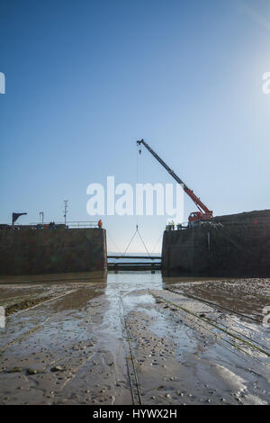 Mousehole, Cornwall, UK. 7. April 2017. Das massive Holz-Baulks, die den Hafen von Mousehole im Winter schützen heute entfernt. Am Wochenende werden die kleinen Fischerboote im Hafen bereit für die kommende Saison wieder genommen werden. Bildnachweis: Simon Maycock/Alamy Live-Nachrichten Stockfoto