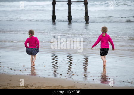 Saltburn am Meer, North Yorkshire, UK. 7. April 2017. Wetter: Trotz der warmen und sonnigen Wochenende prognostiziert, ist es einem kühlen Morgen im Saltburn an der Küste von North Yorkshire, als zwei junge Mädchen Paddel in der kalten Nordsee in der Nähe Saltburns viktorianischen Pier. Bildnachweis: ALAN DAWSON/Alamy Live-Nachrichten Stockfoto