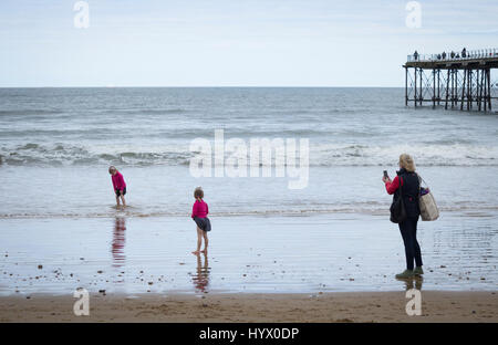 Saltburn am Meer, North Yorkshire, UK. 7. April 2017. Wetter: Trotz der warmen und sonnigen Wochenende prognostiziert, ist es einem kühlen Morgen im Saltburn an der Küste von North Yorkshire, als zwei junge Mädchen Paddel in der kalten Nordsee in der Nähe Saltburns viktorianischen Pier. Bildnachweis: ALAN DAWSON/Alamy Live-Nachrichten Stockfoto