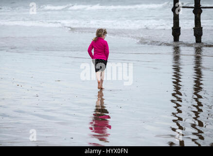 Saltburn am Meer, North Yorkshire, UK. 7. April 2017. Wetter: Trotz der warmen und sonnigen Wochenende prognostiziert, ist es einem kühlen Morgen um Saltburn an der Küste von North Yorkshire als junges Mädchen Paddel in der kalten Nordsee unter Saltburn viktorianischen Pier. Bildnachweis: ALAN DAWSON/Alamy Live-Nachrichten Stockfoto