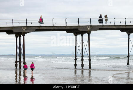 Saltburn am Meer, North Yorkshire, UK. 7. April 2017. Wetter: Trotz der warmen und sonnigen Wochenende prognostiziert, ist es einem kühlen Morgen im Saltburn an der Küste von North Yorkshire, als zwei junge Mädchen Paddel in der kalten Nordsee in der Nähe Saltburns viktorianischen Pier. Bildnachweis: ALAN DAWSON/Alamy Live-Nachrichten Stockfoto