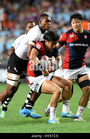 Hong Kong, China. 7. April 2017. Mesulame Kunavula (L) von Fidschi verteidigt die HSBC World Rugby Sevens Serie 2016-2017-Spiel gegen Japan in Hongkong, Südchina, 7. April 2017. Fidschi besiegten Japan 36-0. Bildnachweis: Lo Ping Fai/Xinhua/Alamy Live-Nachrichten Stockfoto