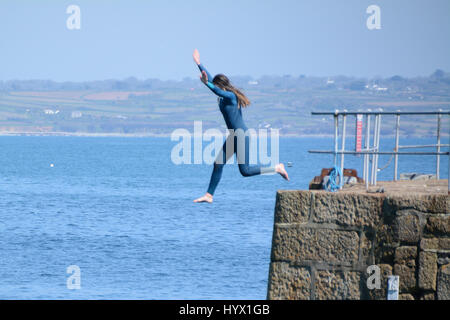 Mousehole, Cornwall, UK. 7. April 2017. Großbritannien Wetter. Sonnigen Nachmittag am Mousehole, mit Mädchen, die von den Wänden Hafen ins Meer springen. Bildnachweis: Simon Maycock/Alamy Live-Nachrichten Stockfoto