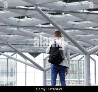 Hintere Ansicht Porträt eines jungen Mannes im leeren Flughafen stehen Stockfoto