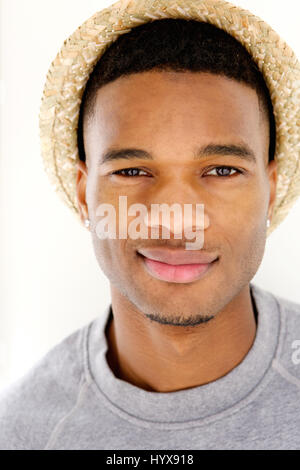 Nahaufnahme Portrait eines coolen jungen Mannes posiert mit Hut auf weißem Hintergrund Stockfoto