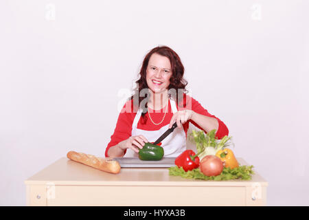 Frau schneidet frisches Gemüse mit viel Spaß. Stockfoto