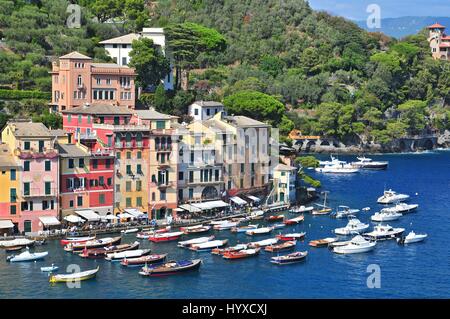 Ligurien-Portofino-Blick auf Hafen mit festgemachten Boote und Pastell farbigen Häusern entlang der Bucht mit Bäumen auf Hügeln hinter Stockfoto