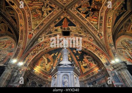 Schrift in Siena Baptisterium mit Marmortabernakel und Statue von Jacopo della Quercia, Panel von Ghiberti und Glauben von Donatello Stockfoto