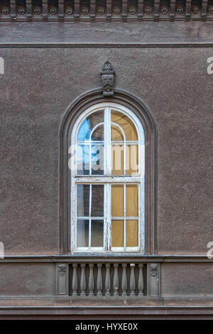 Alte gewölbte Fenster mit verwitterten Holzrahmen Stockfoto