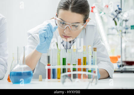 Wissenschaftlerin mit chemische Proben im Reagenzglas im Labor arbeiten Stockfoto