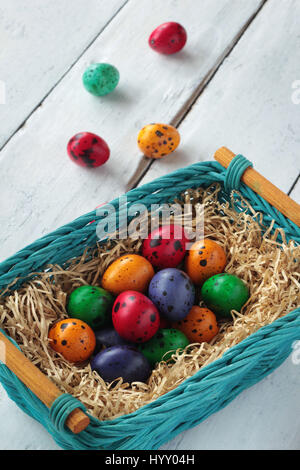 Bunte Ostereier in einem Nest auf weißem Holz Hintergrund Stockfoto