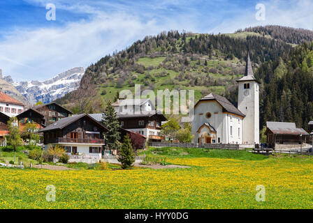 Schöne Alpenlandschaft mit Kirche und typischen Schweizer Häuser am sonnigen Frühlingstag, Inden Dorf, Kanton Wallis, Schweiz. Stockfoto