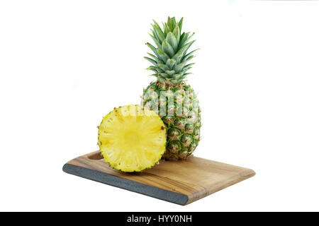 Ein und eine halbe reife Ananas auf dem Holzbrett isoliert auf weißem Hintergrund Stockfoto