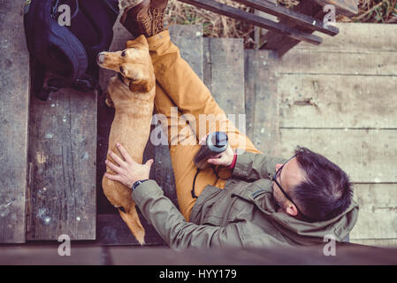 Wanderer und Hund sitzt auf der Treppe der Wanderer ausruhen Kabine Stockfoto