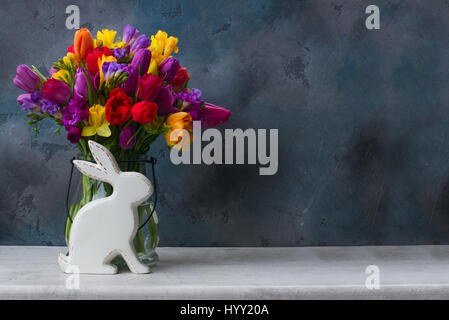 Frühlingsblumen Sie frischen mit weißen Pocelane Osterhase mit textfreiraum auf schwarzem Hintergrund Stockfoto